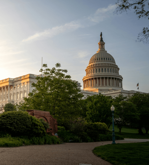 A large white building stands prominently against a clear blue sky, showcasing its elegant architecture and spacious design.