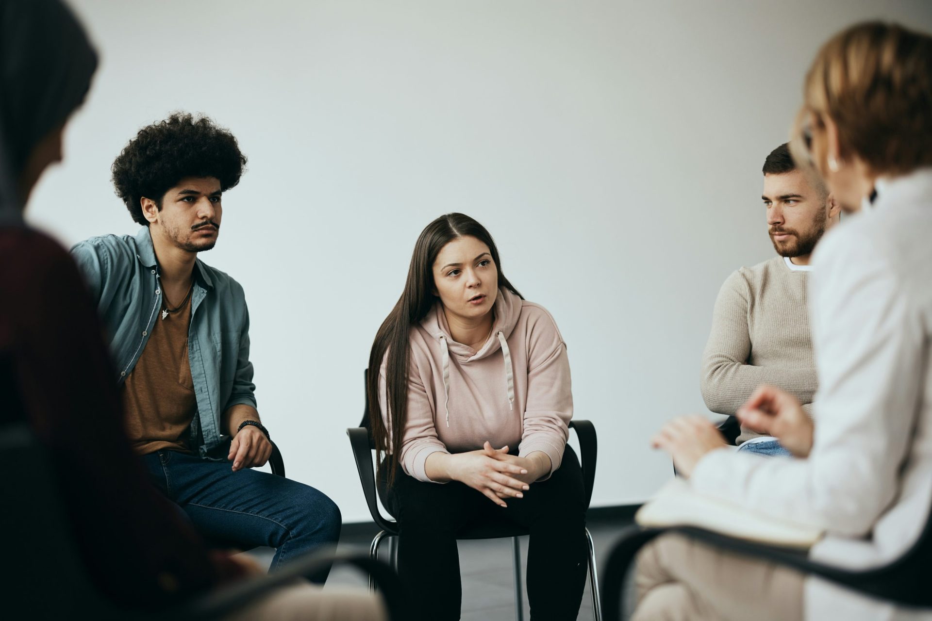 A diverse group of individuals engaged in conversation while seated in a circle, fostering communication and connection.